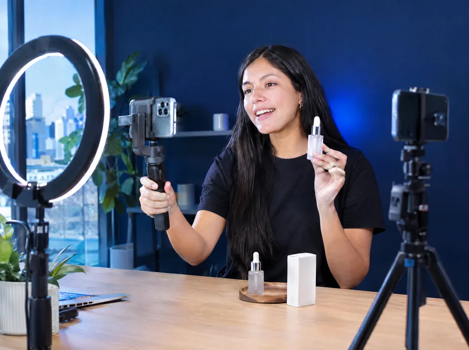 Creadora de contenido grabando un video vertical con un celular y un aro de luz (imagen ilustrativa)